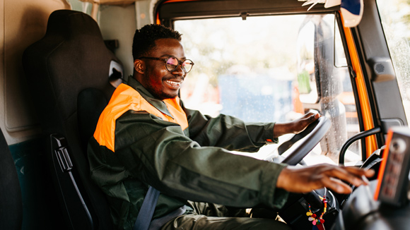 waste removal worker driving a waste truck